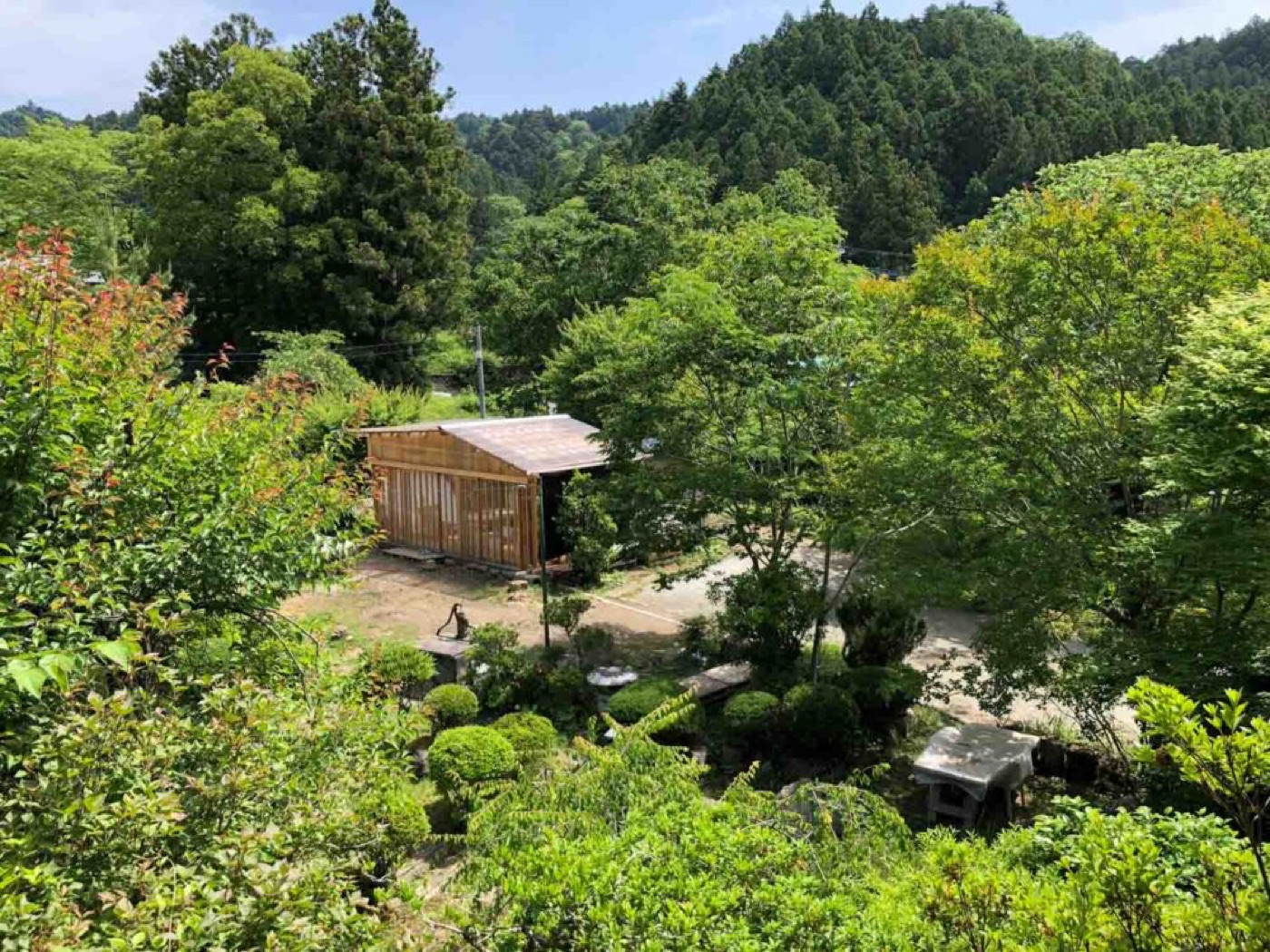 森に囲まれた工房の建物を上から見た様子
