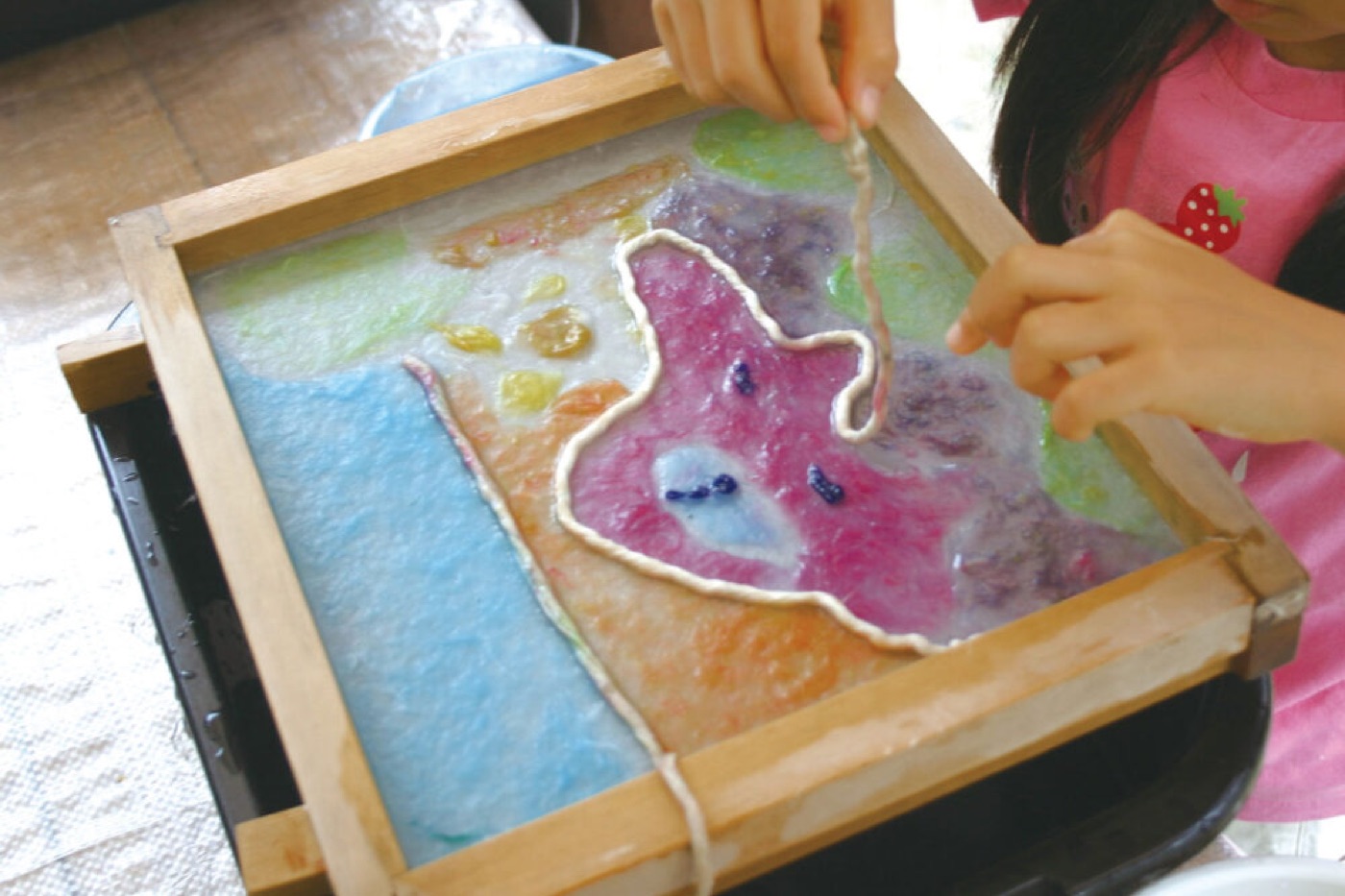 子供が色とりどりの和紙アートを作る様子