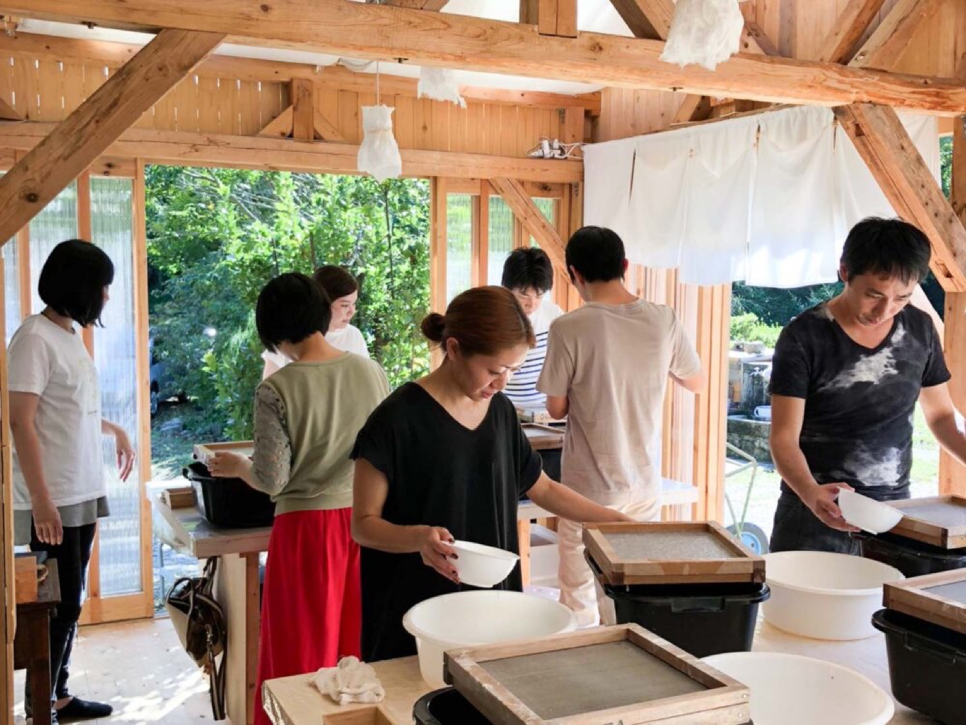 木造の開放的な工房で複数人が紙すきに取り組む実際の様子